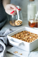 Cooking Homemade granola. Woman filling mason jar with homemade granola. Selective focus.