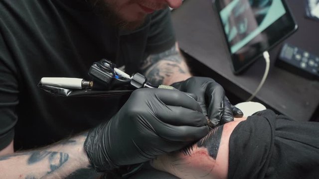 Professional getting tattoo of snake in studio