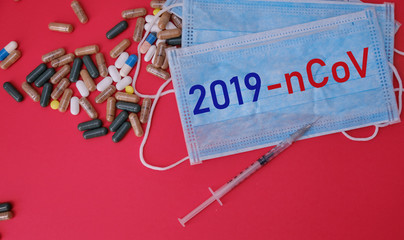 A bunch of pills, injection and medical masks with the words 2019-nCoV 