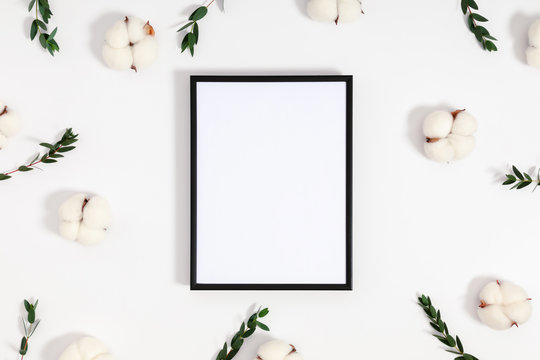 Composition of flowers and eucalyptus. Photo frame, eucalyptus branches and leaves, cotton flowers on white background. Valentines Day, Easter, Happy Women's Day. Flat lay, top view, copy space