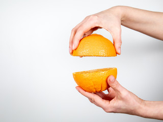 Orange in hand on white background. Vegetarian food and vitamins
