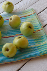 Fresh, ripe Apple harvest. Nature theme with green apples in a white basket on a wooden background. The concept of the nature of the fetus. Top view with space for text
