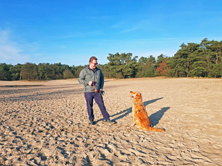 Fototapeta na wymiar Man playing with his dog at the nature reserve Soesterduinen in the Netherlands