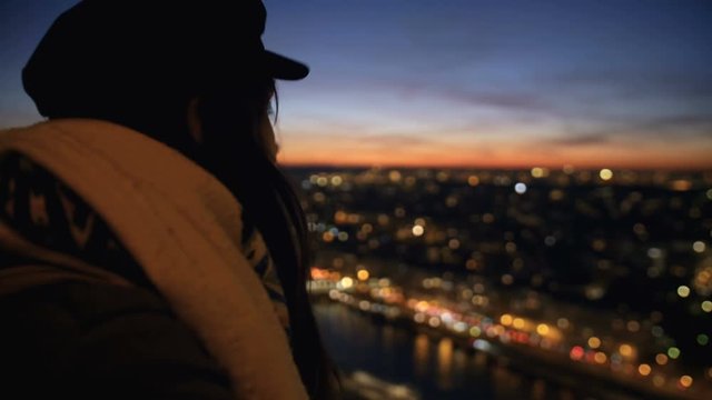Beautiful happy young tourist woman watching incredible sunset city sky from view point, smiling at camera slow motion