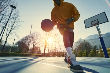  Athletic black man showing his backetball skills on court outdoors. © Alex