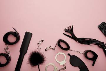 top view of black sex toys on pink background
