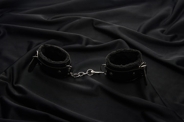 leather handcuffs on black textile background