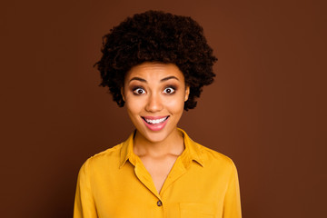 Closeup photo of beautiful pretty dark skin curly lady open mouth cheerful facial expression listen amazing good news wear yellow shirt isolated brown color background