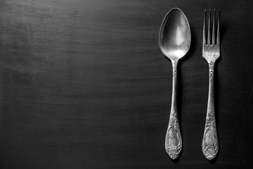 Old fork and spoon over black background