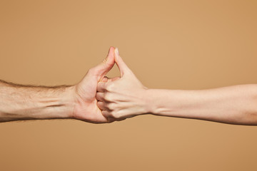 cropped view of man and woman holding hands isolated on beige