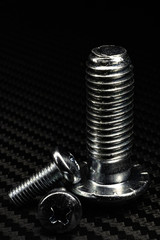 unterschiedlich große schrauben auf untergrund aus carbon