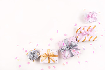 Several gift boxes with bows and confetti on a white background. Flat lay composition. Birthday, christmas, wedding or another holiday concept.