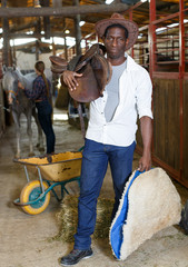 Farm workers preparing horse harness