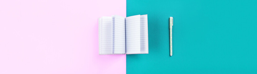 Duotone pink and blue background with open notebook and pen. Diary, planning, studying concept