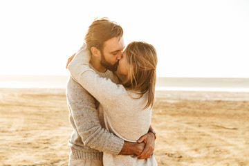 Beautiful young couple standing at the sunny beach