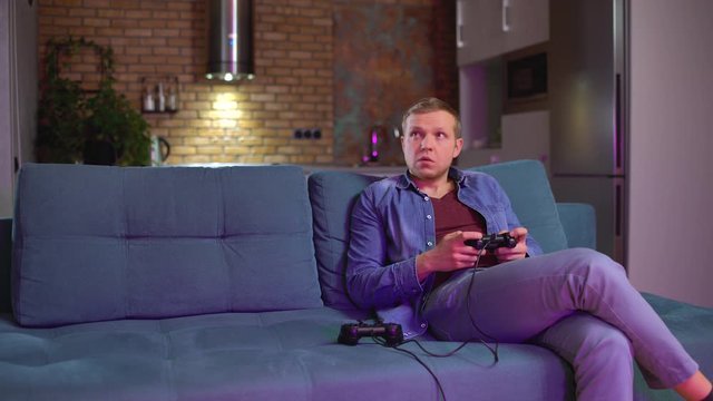 Two friends playing video game console on couch, having fun together, leisure