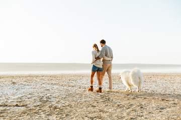 Cheerful young couple walking at the beach