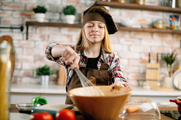 Little girl in kitchen. Cute girl cooking .