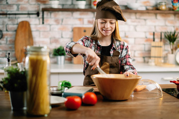 Little girl in kitchen. Cute girl cooking .