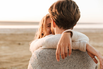 Beautiful young couple standing at the sunny beach