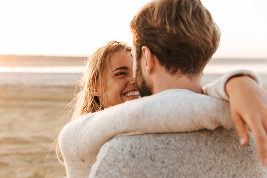 Beautiful young couple standing at the sunny beach - Powered by Adobe