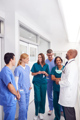 Multi-Cultural Medical Team Having Meeting In Hospital Corridor