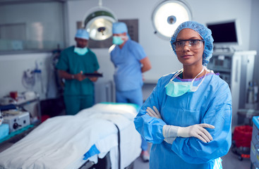 Portrait Of Female Surgeon Wearing Scrubs And Protective Glasses In Hospital Operating Theater