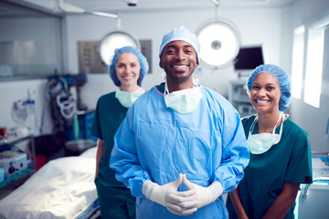 Portrait Of Multi-Cultural Surgical Team Standing In Hospital Operating Theater