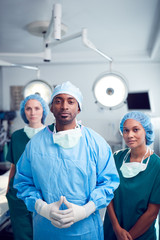 Obraz premium Portrait Of Multi-Cultural Surgical Team Standing In Hospital Operating Theater