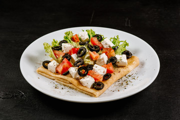 Thin pancakes with vegetables on black background