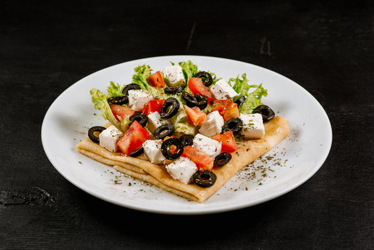 Thin pancakes with vegetables on black background