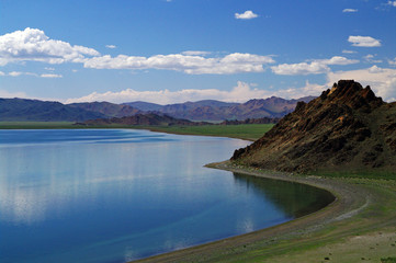 Western mongolian lake amonge the mountains and blue sky with clouds