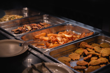 Set of side dishes of a self-service restaurant - potatoes, breaded vegetables and others