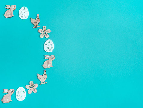 Easter composition. Wooden decorations in the form of Easter symbols on a light blue background. Free space.