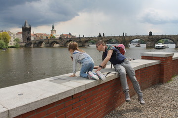 man and child look at the river near Charles bridge, Prague