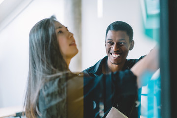 Joyful black man looking at colleague during work
