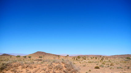 Bright landscape of Morocco, breathtaking curves of mountains, stunning combination of hills & farm land,inadvertent distribution of houses & huts, raw impression of pure nature.