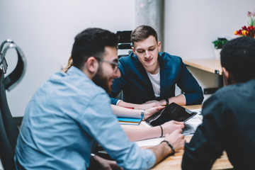 Young man sitting amidst colleagues in meeting room