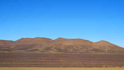 Bright landscape of Morocco, breathtaking curves of mountains, stunning combination of hills & farm land,inadvertent distribution of houses & huts, raw impression of pure nature.
