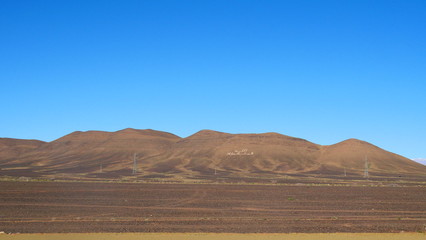 Bright landscape of Morocco, breathtaking curves of mountains, stunning combination of hills & farm land,inadvertent distribution of houses & huts, raw impression of pure nature.