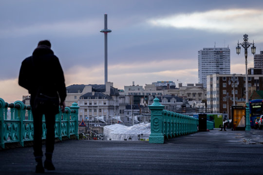 man walking along Brighton sea front