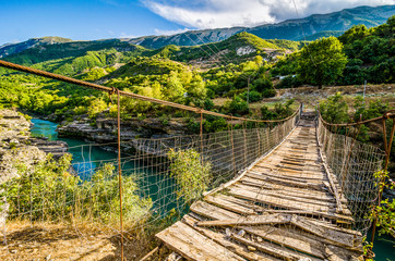 Old broken wooden bridge over Aoos river near Permet in Albania