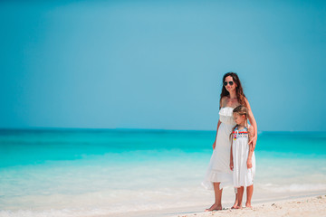 Beautiful mother and daughter at the beach enjoying summer vacation.