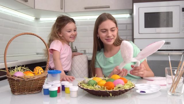 Happy easter. Two sisters painting Easter eggs. Happy family children preparing for Easter. Cute little child girl wearing bunny ears on Easter day.
