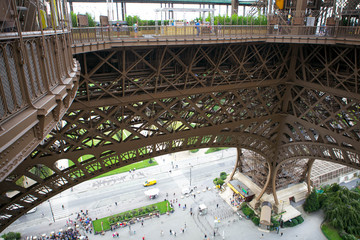 August 2011. Paris. People at the foot of the building and the first floor of the Eiffel Tower.