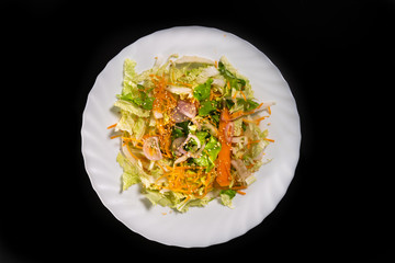  Mixed salad, fresh, light and colorful, in a white plate, on a black background
