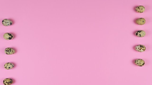 Stop motion animation of quail eggs roll on pink background, flat lay. Concept Easter Holiday and spring 