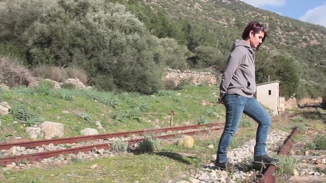 woman crossing the tracks of the abandoned railroad