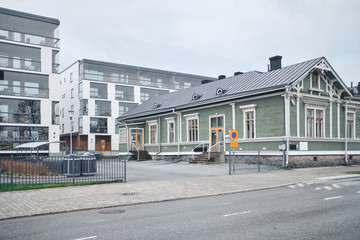 The old wooden building and the brand new modern apartment building in Joensuu, Finland. Retro and modern.
