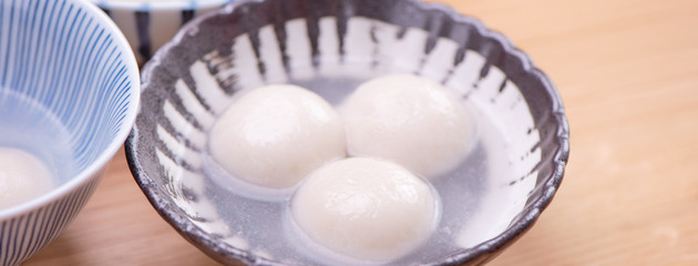 Tang yuan, tangyuan, yuanxiao in a small bowl. Delicious asian traditional festive food rice dumpling balls with stuffed fillings for Chinese Lantern Festival, close up.